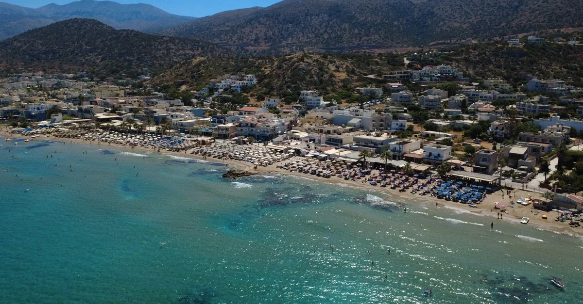 Superbe vue aérienne de la plage de Stalída, en Crète, mettant en valeur ses eaux d'un bleu cristallin et sa vie côtière animée.