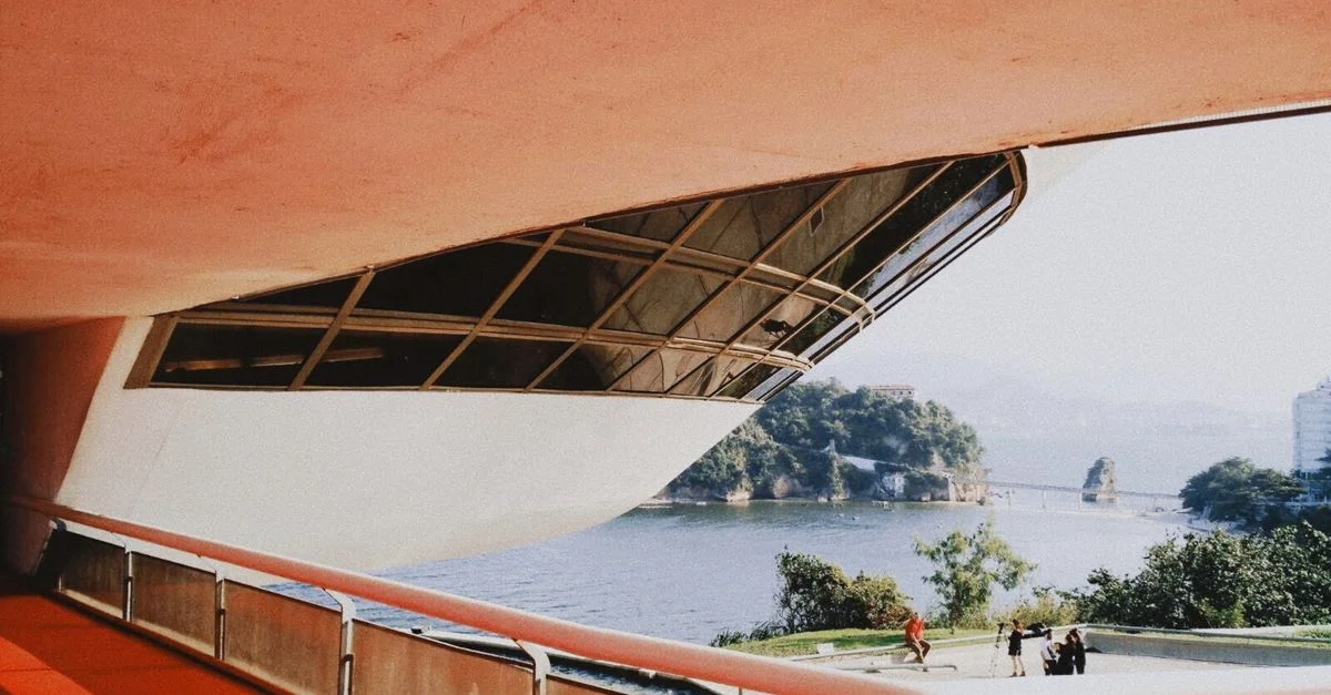 Une vue imprenable de l'architecture d'un bâtiment moderne avec la côte brésilienne en arrière-plan, mettant en valeur l'esthétique culturelle.