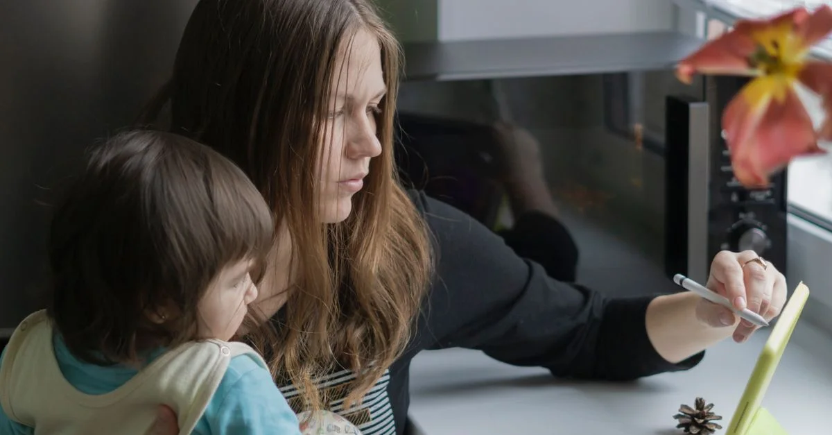 Une mère et sa fille renouent des liens en utilisant une tablette dans un cadre intérieur chaleureux.