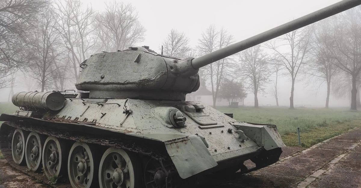 Char soviétique T-34 exposé à l'extérieur par un matin d'hiver brumeux entouré d'arbres.